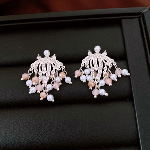 Dettaglio di orecchini a ventaglio in argento con nappe di perle rosa e diamanti sintetici