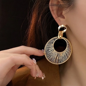 Chic gold-toned hollow woven circular earrings featuring intricate wire geometry design
