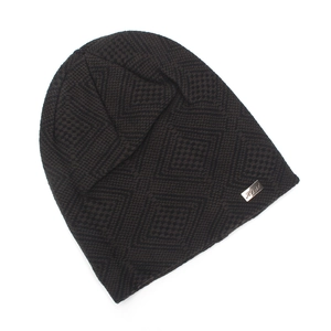 Detail of dark brown knit beanie with geometric pattern and metal Heat brand tag