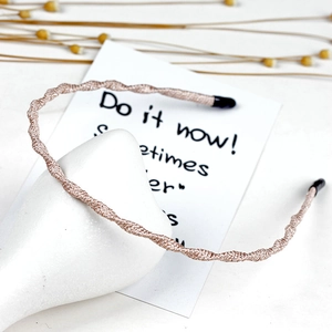 Detail of pink woven fabric headband with black ends on decorative prop and card