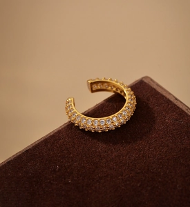Close-up of golden S925 sterling silver ear cuff with three rows of sparkling crystals