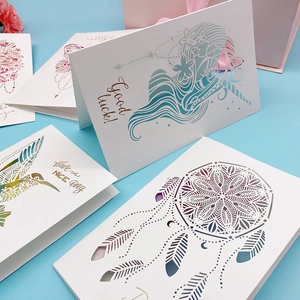 Macro detail of laser-cut 3D greeting cards featuring unicorn and hummingbird designs