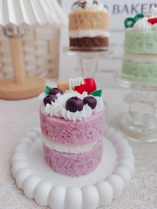 Macro view of strawberry double-layer cake scented candle with creamy topping and fruit detail