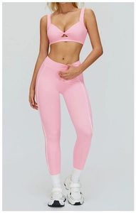 Dettaglio del set yoga rosa con strisce laterali a contrasto e reggiseno sportivo a nodo