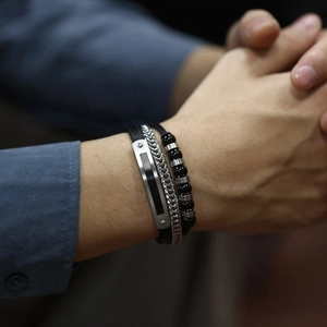 Détail d'un ensemble de bracelets pour hommes en cuir noir, chaîne métal et perles