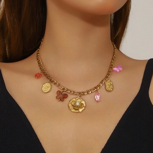 Collier plaqué or avec fleur de camélia, pendentif rose et breloques papillon au cou