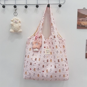 Detail of pink canvas tote with cartoon bear patterns and a 3D floral charm accessory