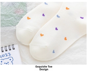 Macro detail of seamless toe stitching on cotton socks with colorful heart patterns