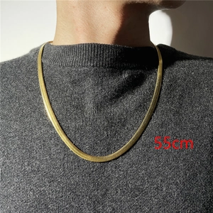 Dettaglio di una collana a catena piatta color oro da 55 cm su una modella