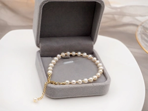 Detail of freshwater pearl bracelet with gold spacers in a velvet jewelry box