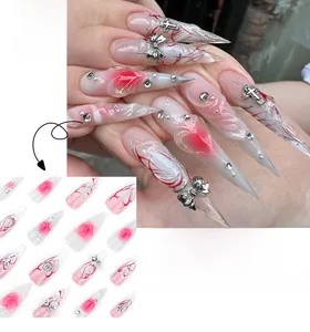 Close-up of extra long stiletto nails with 3D silver bows and red abstract line art