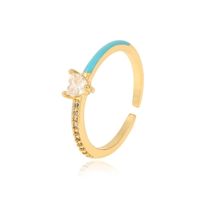 Macro detail of gold heart ring featuring blue enamel and sparkling cubic zirconia