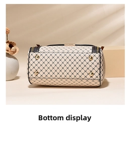 Detail view showing the structured bottom of a Boston bag with four gold protective metal studs