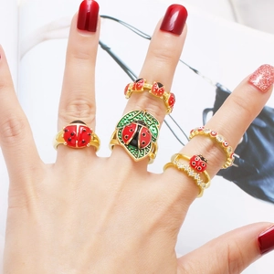 Lot de 5 bagues dorées coccinelle avec émail rouge et détails de feuilles vertes