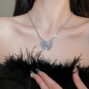 Gros plan d'un collier en argent avec pendentif papillon en zircon porté par un mannequin