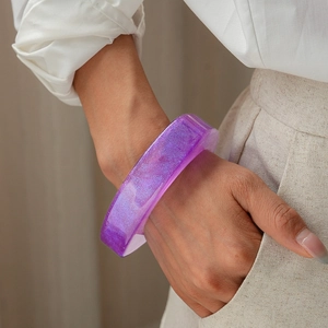 Close-up of translucent purple resin cuff bracelet with glitter on model's wrist