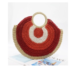 Detail of round straw handbag with red, orange and beige tricolored woven pattern