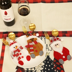 Detailed view of festive Santa, snowman, and reindeer cutlery holders on a holiday table