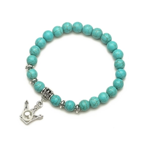 Blue turquoise beaded bracelet with silver crown pendant and white pearl on white background