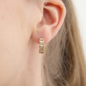 Close-up of 18k gold plated stainless steel hoop earring with rectangular zircons on ear