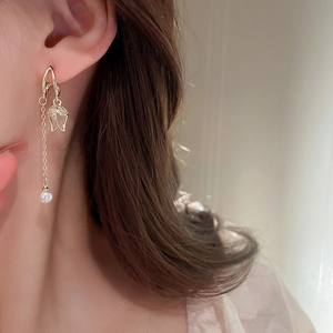 Detailed view of tulip-shaped earring with dangling pearl and sparkling small zircon accents