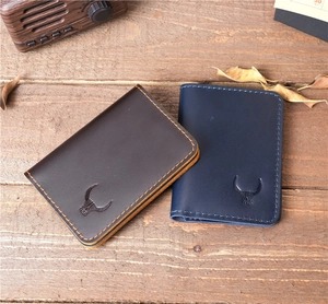 Flat lay of brown and blue crazy horse leather card holders with embossed bull logo
