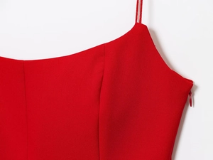 Detail view of red strapless dress showing the neckline cut and side zipper texture