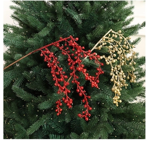 Close-up of glittered red and gold Christmas berry picks on green pine branches