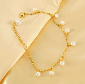 Detail of 18K gold plated anklet featuring elegant pearls on a soft silk background
