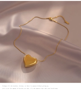 Detail shot of a golden heart pendant necklace on soft silk fabric with elegant draping