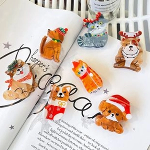 Flat lay of seven cute animal acetate hair clips on a magazine with bright soft lighting