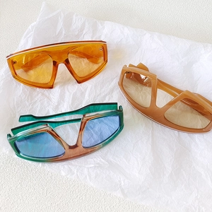 Three pairs of oversized trendy gradient sunglasses displayed on white textured background