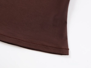 Detail of soft brown knit fabric showing precision double-needle stitching and hem finish