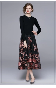 Close-up of intricate red floral embroidery on black mesh skirt of a two-piece set