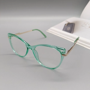 Detail of mint green cat-eye frame with slim gold metal spring hinges and temples