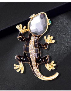 Close-up of crystal lizard brooch with black enamel and sparkling rhinestones