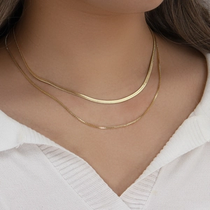 Close-up of double-layered 18K gold plated flat snake chain and delicate link necklace