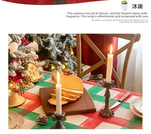 Detailed texture of red and green plaid Christmas tablecloth with vintage bronze candle