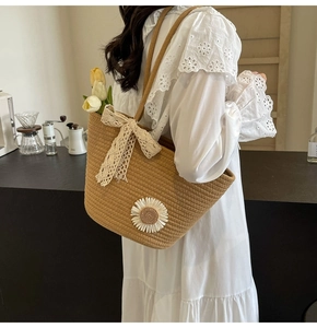 Detail of hand-woven tote bag with sunflower appliques and lace bow decoration