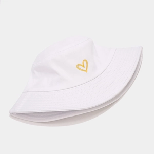 Détail de la broderie de cœur jaune sur le chapeau bob en coton blanc de haute qualité