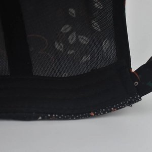 Detailed close-up of breathable black mesh fabric and patterned piping on baseball cap