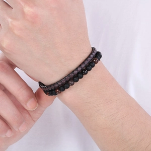 Detail of brown braided leather bracelet paired with black matte and red tiger eye beads