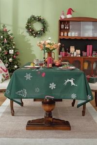 Close-up of dark green Christmas tablecloth with reindeer and snowflake patterns on wood