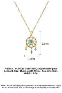 Detailed view of gold dreamcatcher pendant with blue stone and teardrop charms on chain