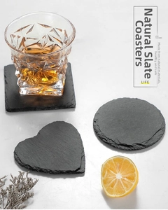 Detail of square, round, and heart-shaped natural black slate coasters with raw split edges