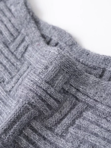 Detailed macro view of the soft grey knit fabric texture with intricate ribbed patterns