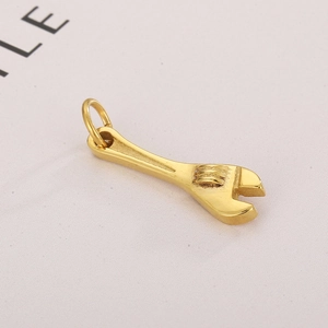 Detailed close-up of a golden mini wrench tool pendant with a polished metallic finish