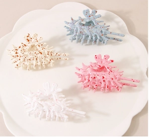 Artistic shell-shaped hair claws in pastel colors with colorful speckled patterns