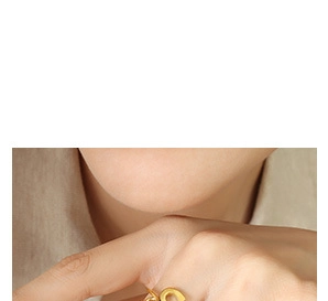 Close-up of a minimalist golden ring with unique design worn on finger in soft lighting