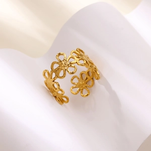 Close-up of golden hollow flower pattern ring with polished titanium steel finish